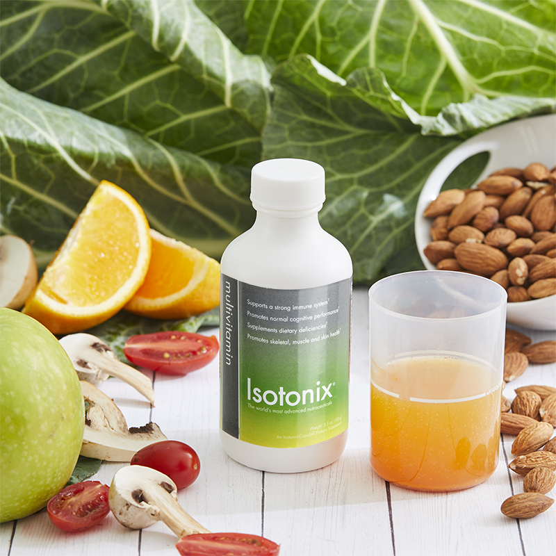 Isotonix Multivitamin Without Iron 30 Servings, liquid serving cup partially filled, with sliced oranges, bowl of nuts, mushrooms and sliced tomatoes