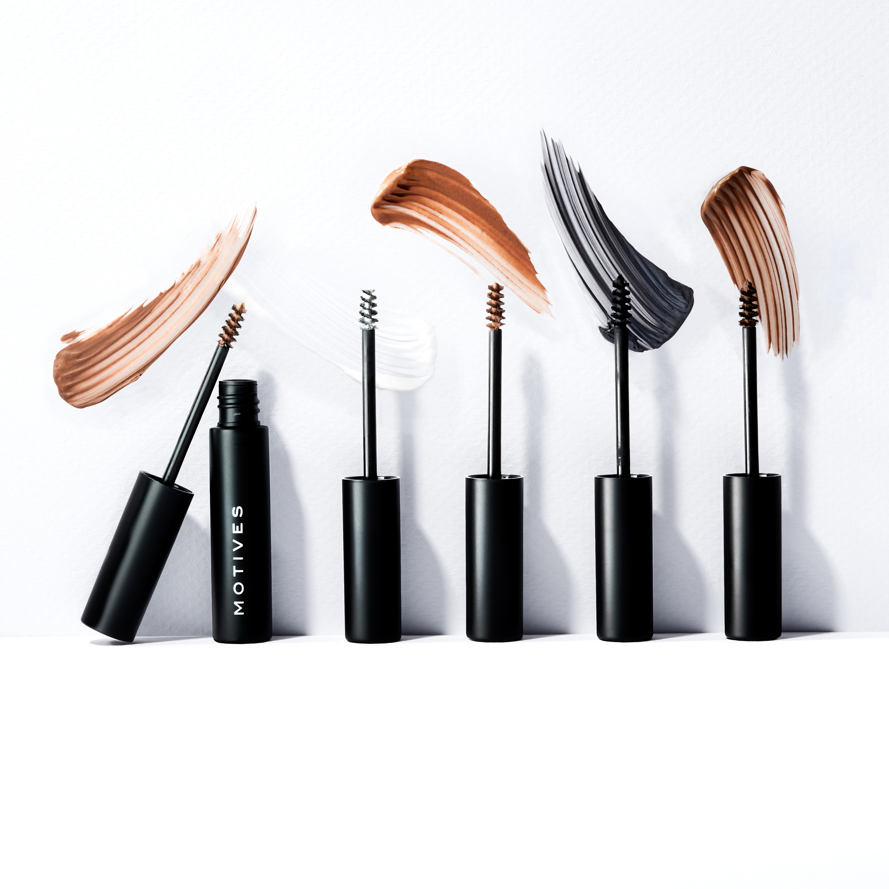 All 5 shades of Motives Gel-ous Brow Gel side by side with spoolie applicator and swatches of each shade shown.