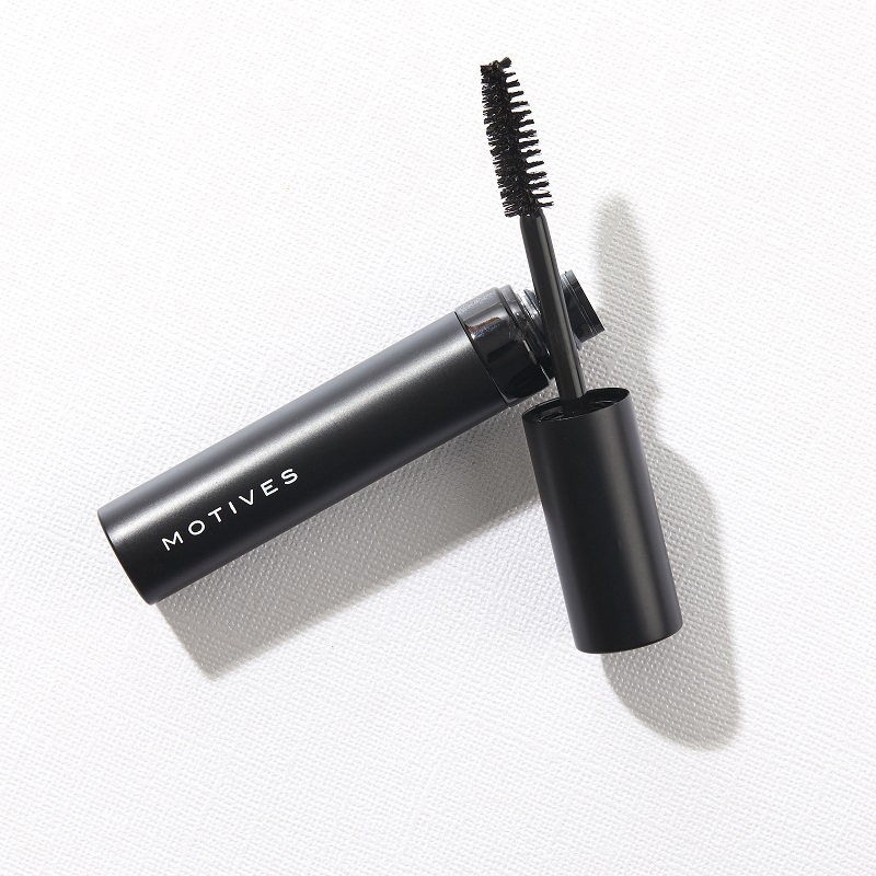 Motives Lustrafy Waterproof Mascara open and lying on its side, showing thick brush