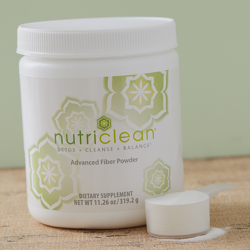 NutriClean Advanced Fiber Powder with Stevia, a tasty way to cleanse, shown mixed in a glass of water on a table with a napkin and spoon