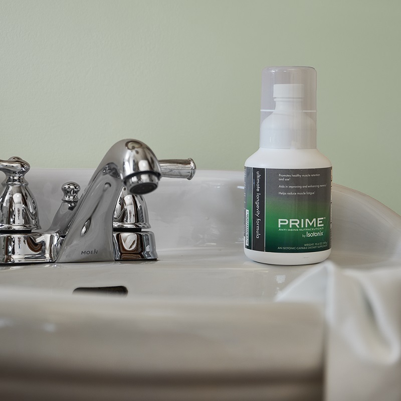 Prime Ultimate Longevity Formula by Isotonix®, sitting on a bathroom sink with a towel