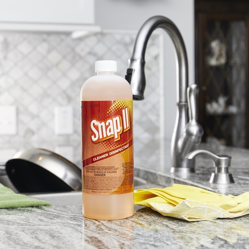 Snap II Cleaner Disinfectant bottle, sitting next to sink containing pots