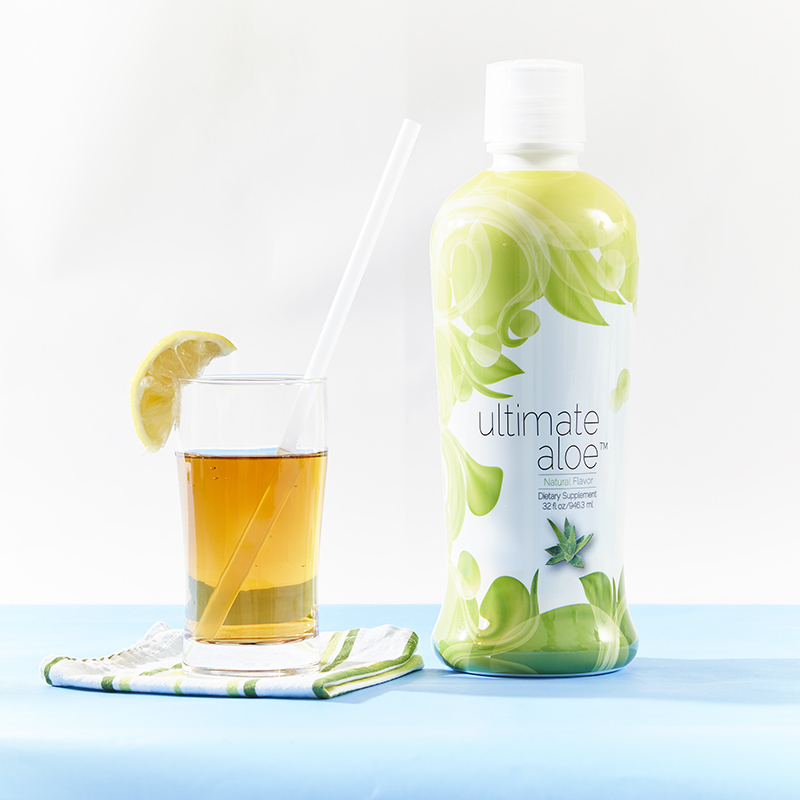 Ultimate Aloe Image and a drinking glass with a lemon wedge on it
