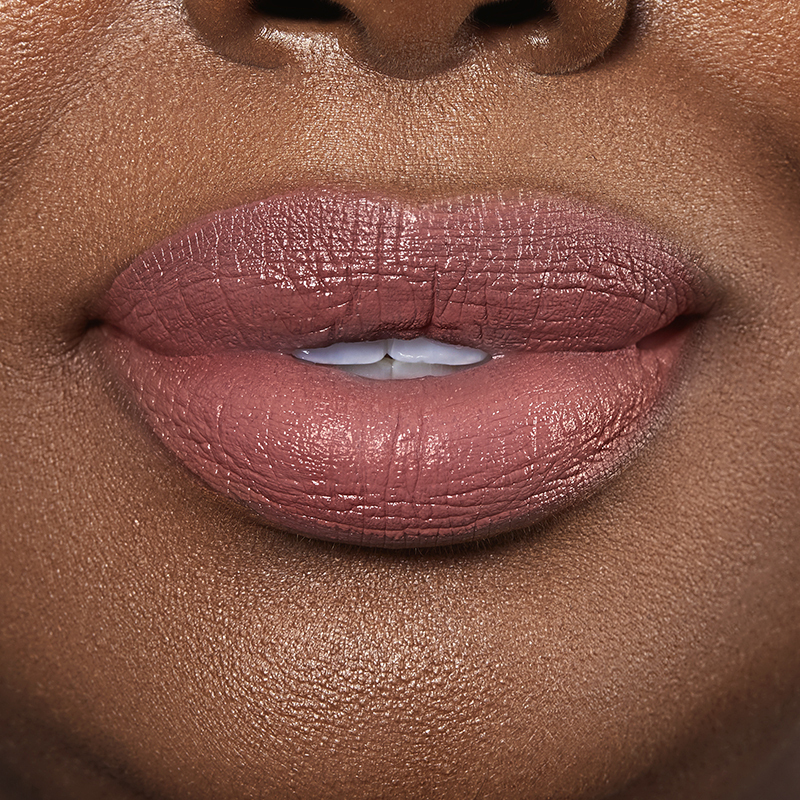 Closeup on lips of model with dark skin tone wearing Motives Liquid Lipstick, color Savage