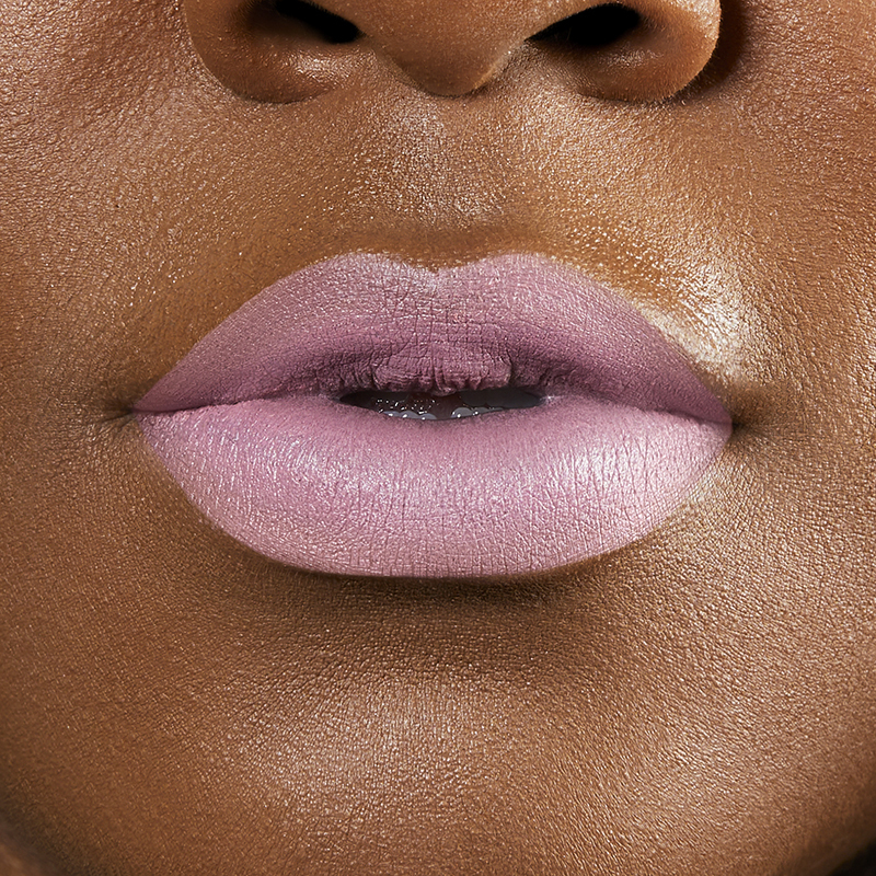 Closeup on lips of model with dark skin tone wearing Motives Cream Lipstick, color Cupcake
