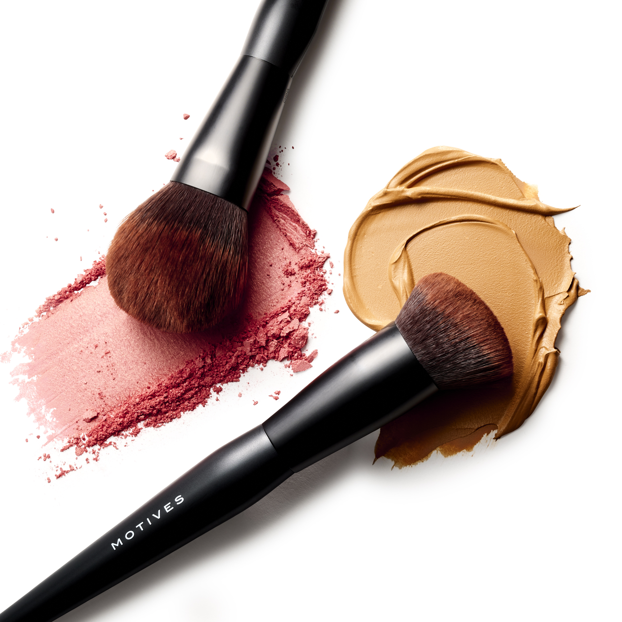 Powder brush and foundation brush from Motives Essential Complexion 4-Piece Brush Set shown with swatches of different textured cosmetics.