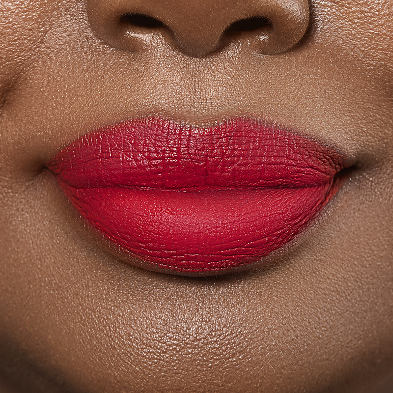 Closeup on lips of model with dark skin tone wearing Motives Liquid Lipstick, color Give Me Lip