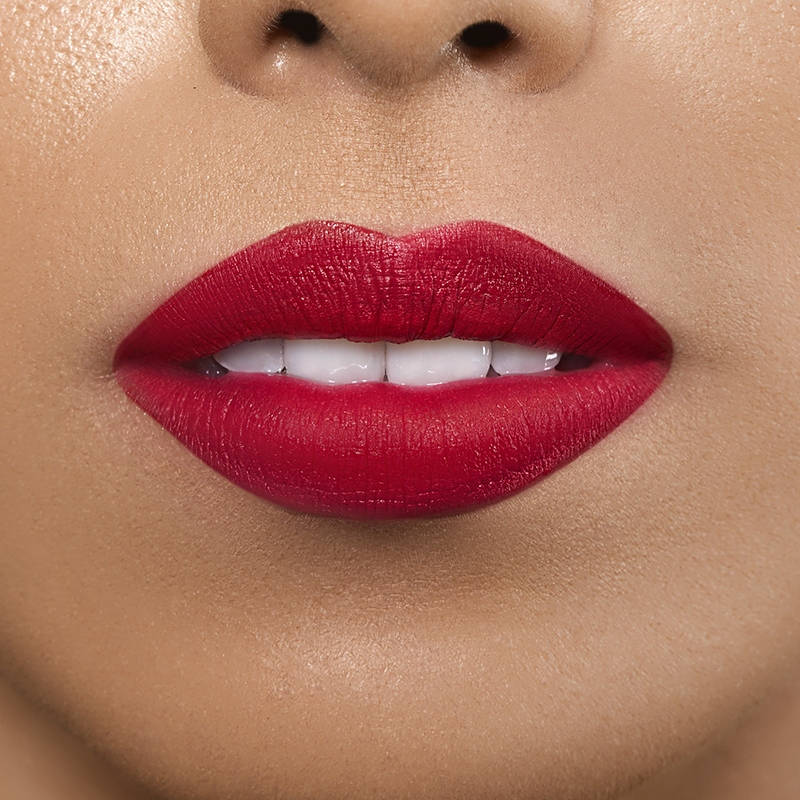 Closeup on lips of model with medium skin tone wearing Motives Liquid Lipstick, color Give Me Lip