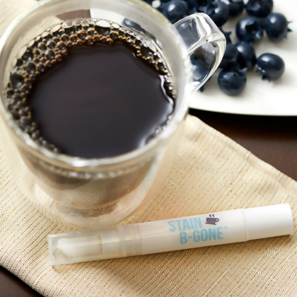 Cup of coffee sitting on a beige towel and blueberries, with Dr. Brite Teeth Whitening Pen