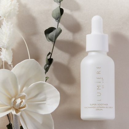 Lumière de Vie Super Soother (Niacinamide/Vitamin B3 Serum) pictured with a white flower