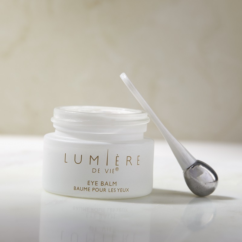 Lumière de Vie Eye Balm open container and the applicator leaning on the container