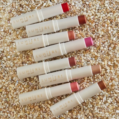 Lumière de Vie Lumi-Stick opened lipstick tubes on a textured surface