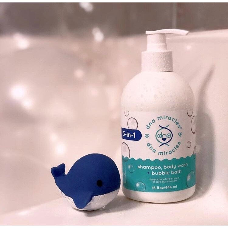 DNA Miracles 3-in-1 Shampoo, Body Wash + Bubble Bath, sitting on the side of a bathtub with a toy whale