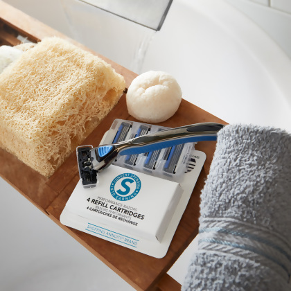 Shopping Annuity Brand Performance Razors Refill Cartridges with a razor on top with a gray towel and lufa