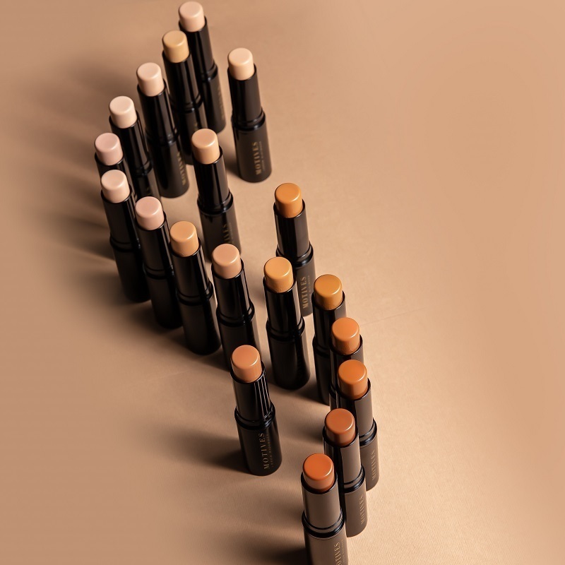 Motives Flawless Face Bundles, of Flawless Face Stick Foundations, with open tops showing foundation shades, standing on end in an "S" curve