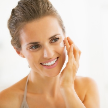 Woman applying Cellular Laboratories De-Aging Sunscreen Broad Spectrum SPF 50+ to her cheek.