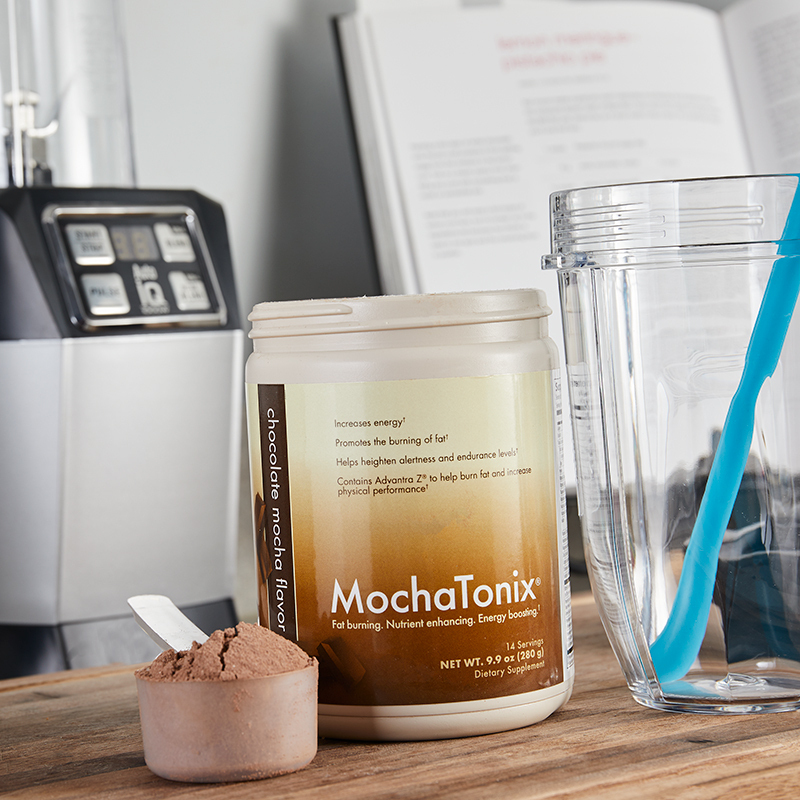 MochaTonix Single Canister Chocolate Mocha Flavor, with a serving scoop filled with powder product and adjacent glass with a straw