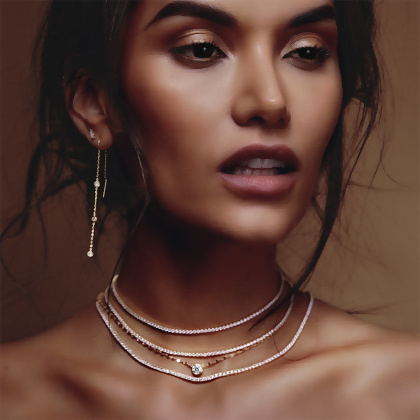Model wearing multiple Layered AYVA - Round Cut Tennis Chokers with KATIE - Textured Solitaire Necklace and other earrings