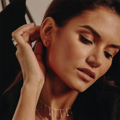 Model wearing 2 pairs of Layered ISABELLA - Baguette Mini Studs earrings in both Silver with Clear Gem and Silver with Green Gem, a necklace and rings