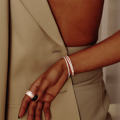 Model wearing Layered Layered VIOLET - Round Cut Tennis Bracelet in silver with clear gems, and stacked rings