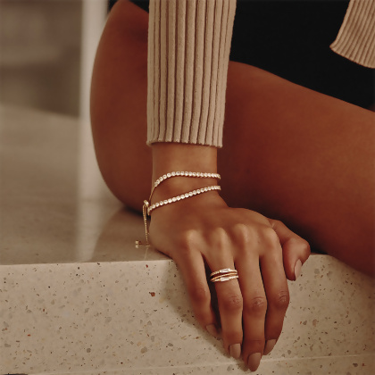 Model wearing Layered VIOLET - Round Cut Tennis Bracelet and stacked rings