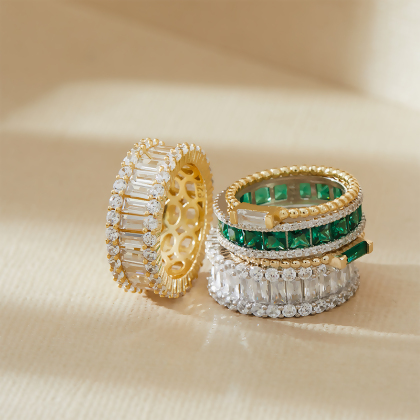 Closeup of Layered JOY - Princess Cut Eternity Band, Silver with Clear Green Gem, with other rings