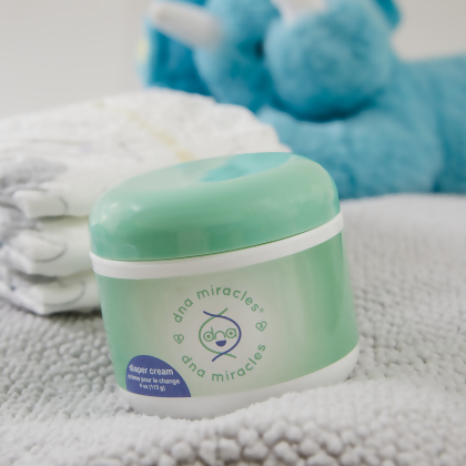 DNA Miracles Natural Diaper Cream with diapers and a blue Teddy Bear