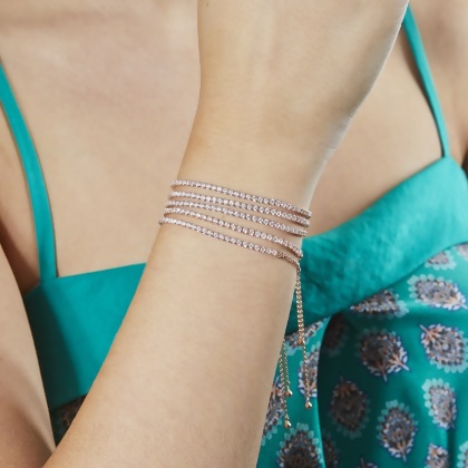 Closeup of model wearing 5 stacked Layered BRIA Round Cut Tennis Bracelets in rose gold