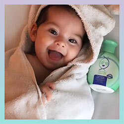 Kid wrapped in towel next to DNA miracles lotion