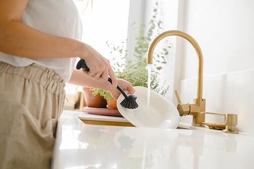 Person washing dishes at a sink