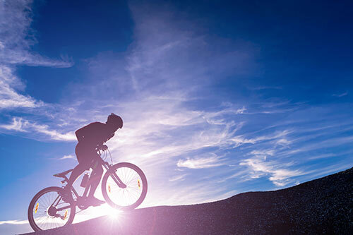person riding bike at sunrise