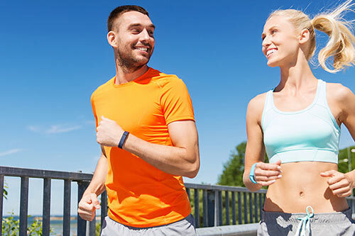 Two people smiling outside while on a run.