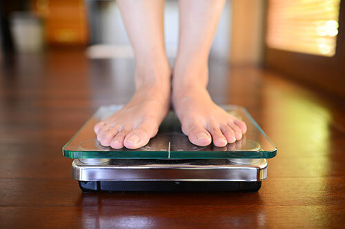 Feet standing on a scale.