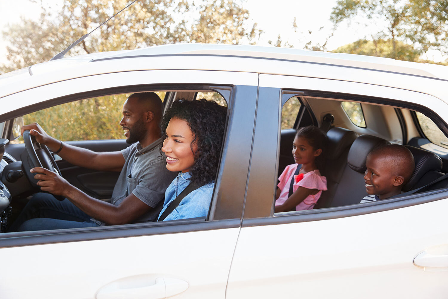 Young black family smiling in car